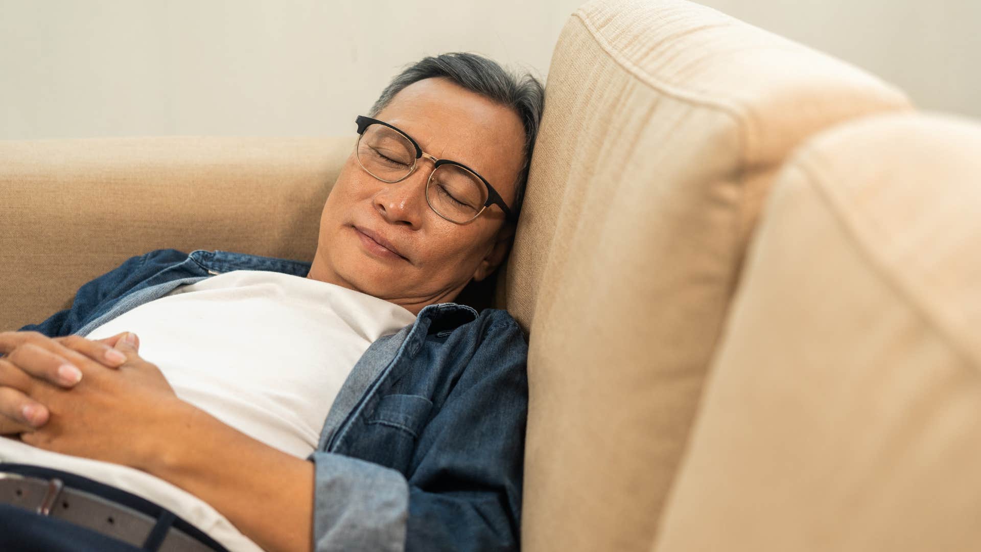 peaceful older person sleeping on couch