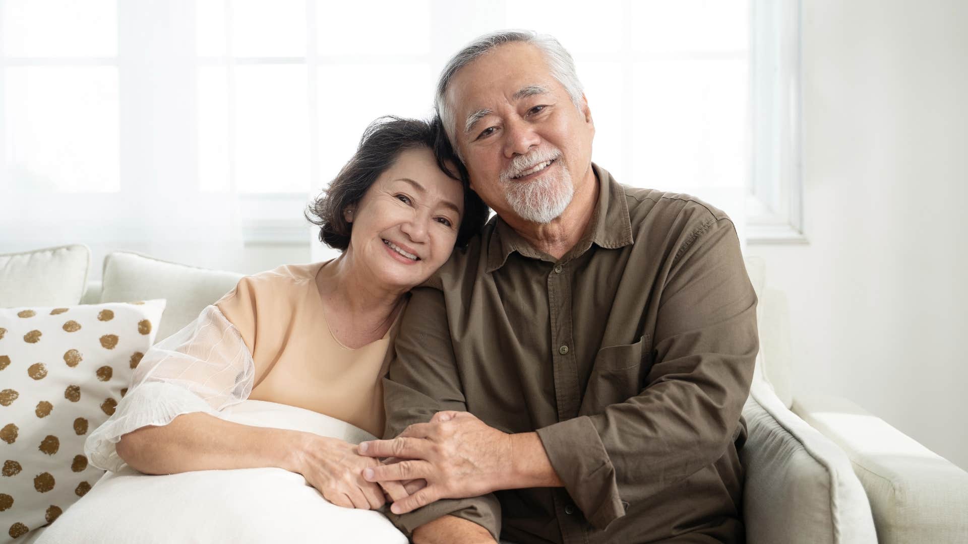 happy older couple hold hands showing realistic marriage