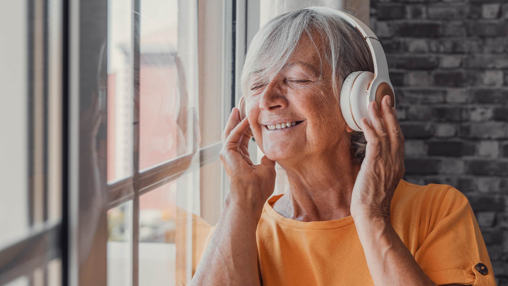 happy older person with headphones showing music quiets mind