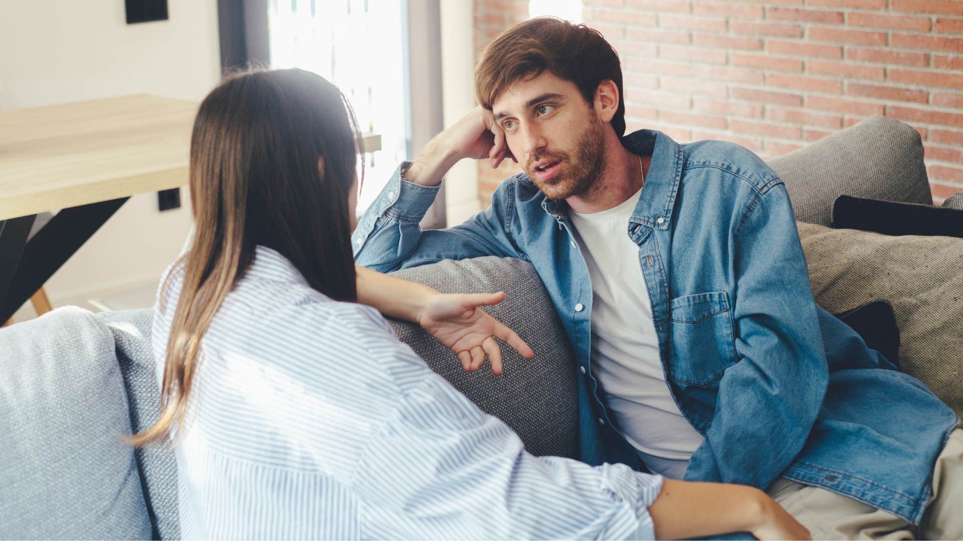 man listening to woman speak on couch as they are emotionally deep