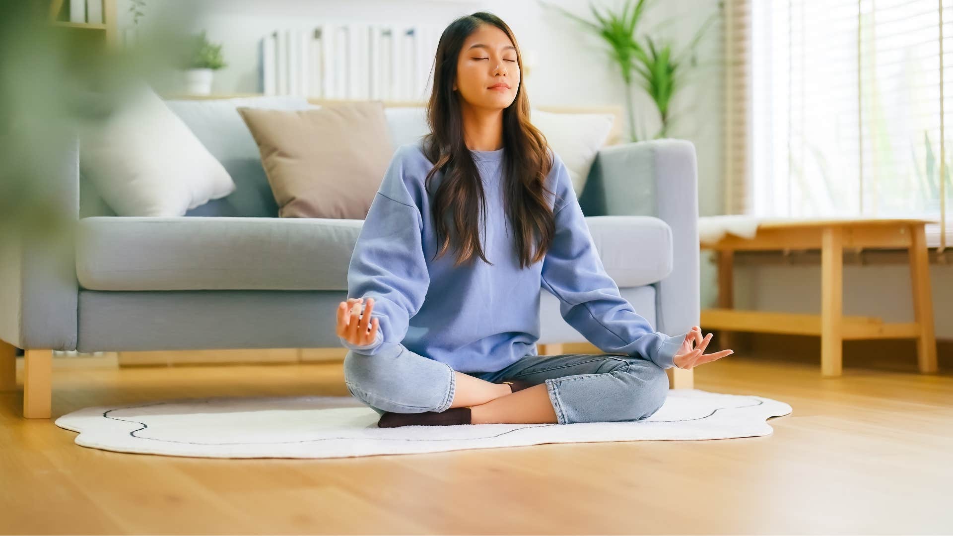 woman in blue shirt meditating as she's emotionally self regulated