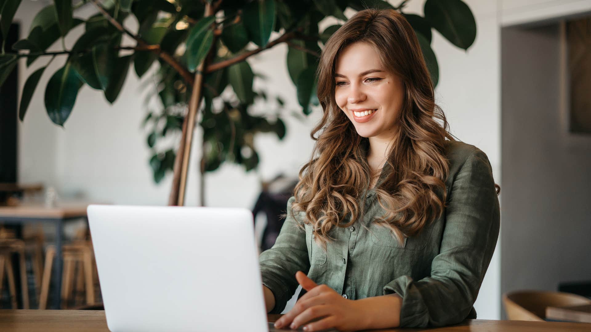 woman smiling and looking at laptop as she's mentally organized