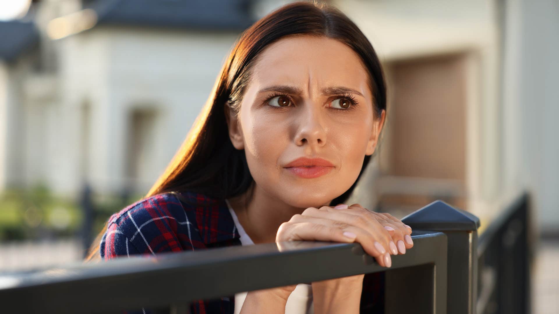 woman being observant as she looks over fence