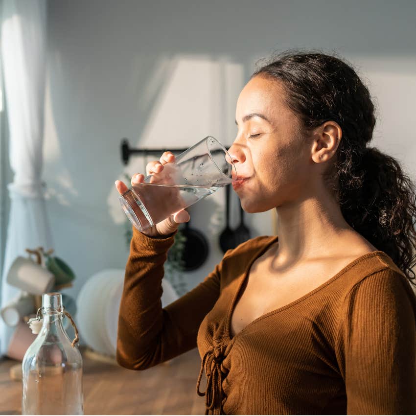 Woman drinking a glass of water with intention by saying what she is doing