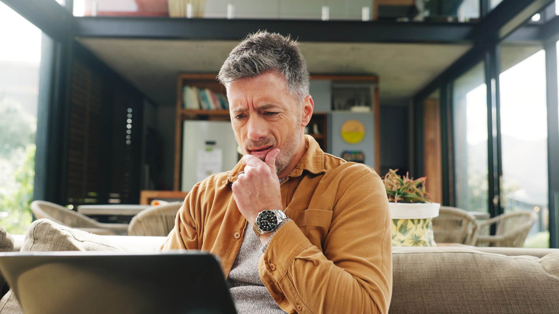 man with a future-focused mindset thinking while working on laptop