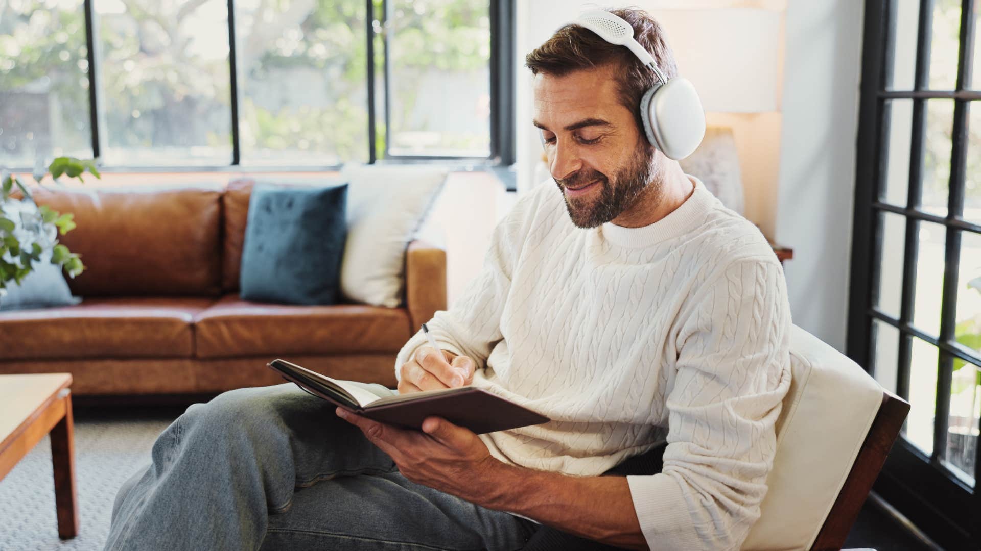 creative and imaginative man listening to music and journaling