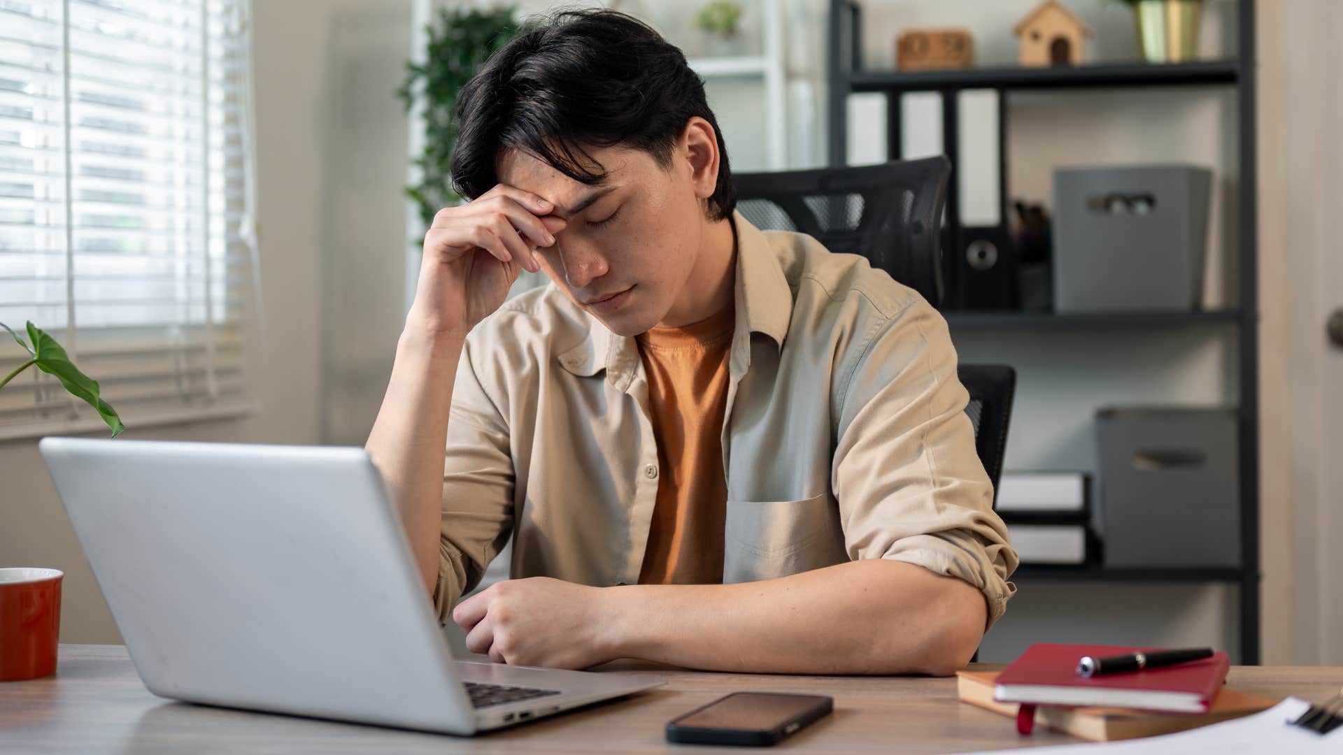 man who holds a lot of tension in his body working at home