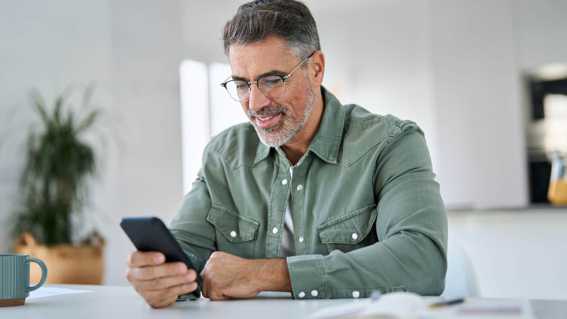 Man who's a planner writing in calendar at home.
