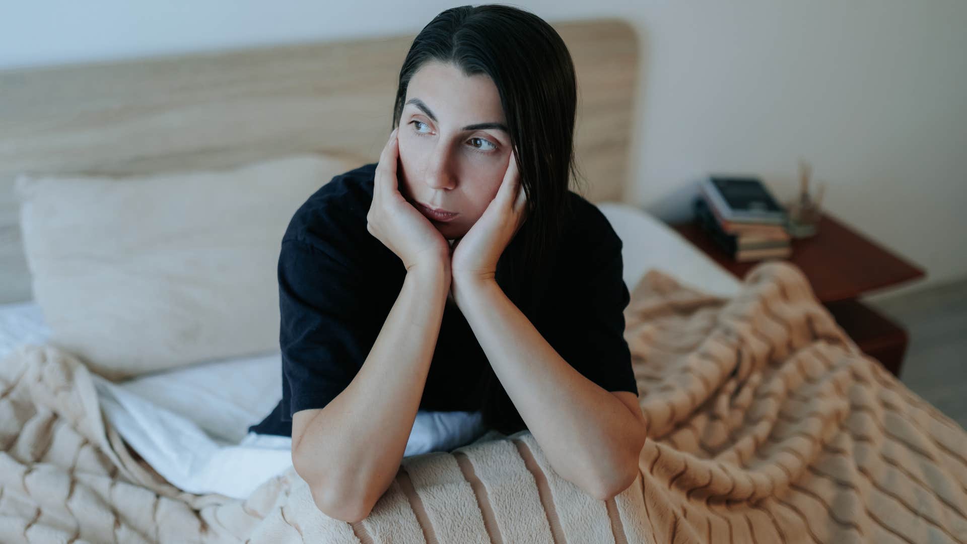 woman waking up in bed after grinding her teeth all night