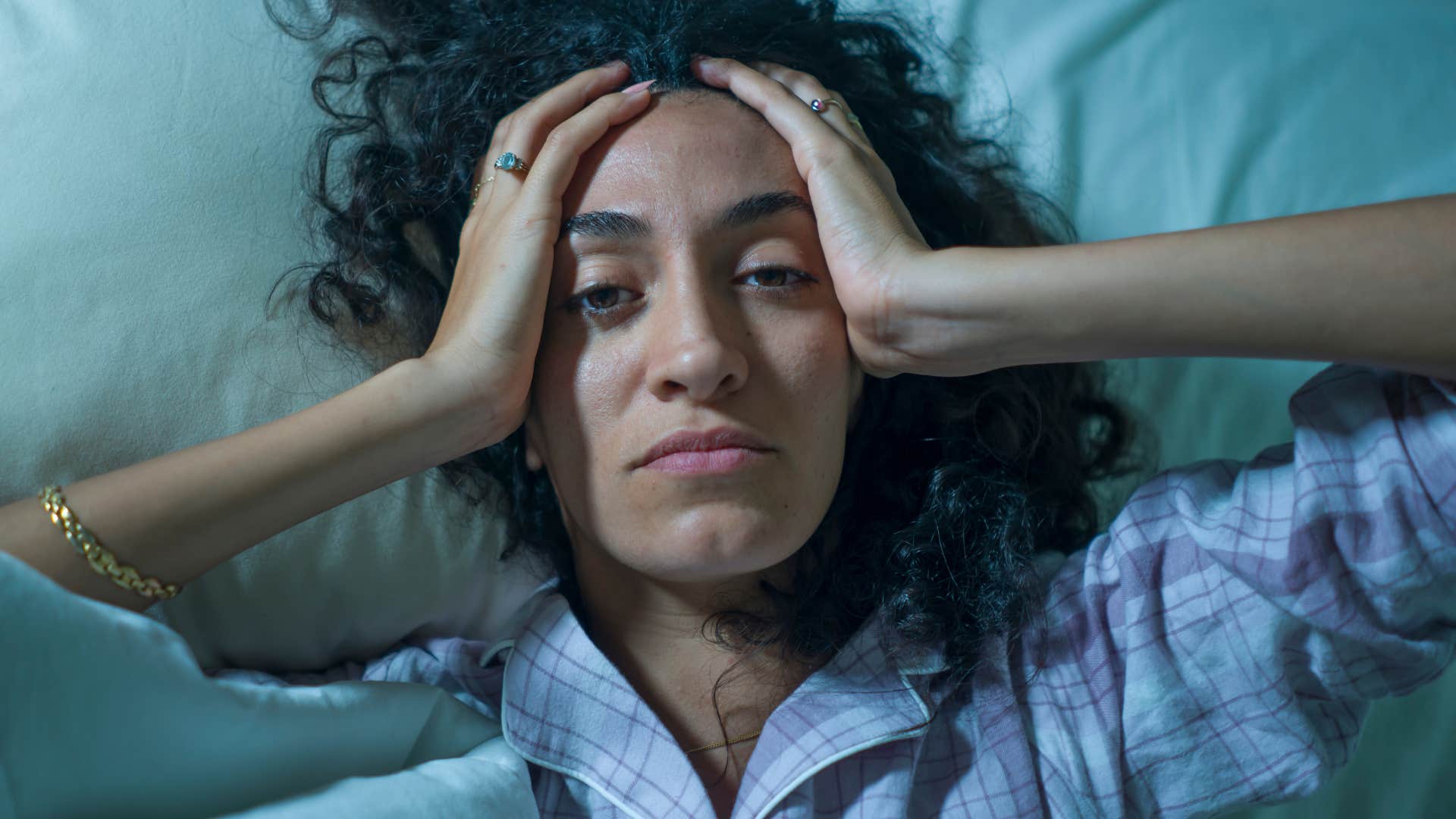 woman who snores often lying in bed awake feeling stressed
