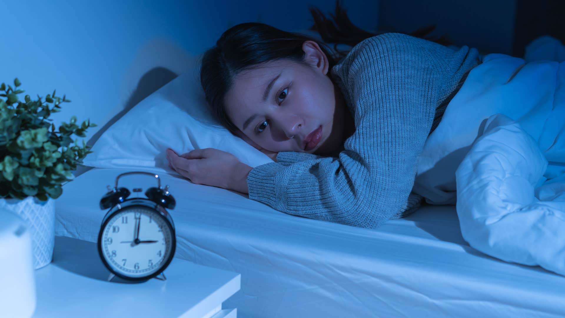 woman who tosses and turns in bed lying awake in the dark