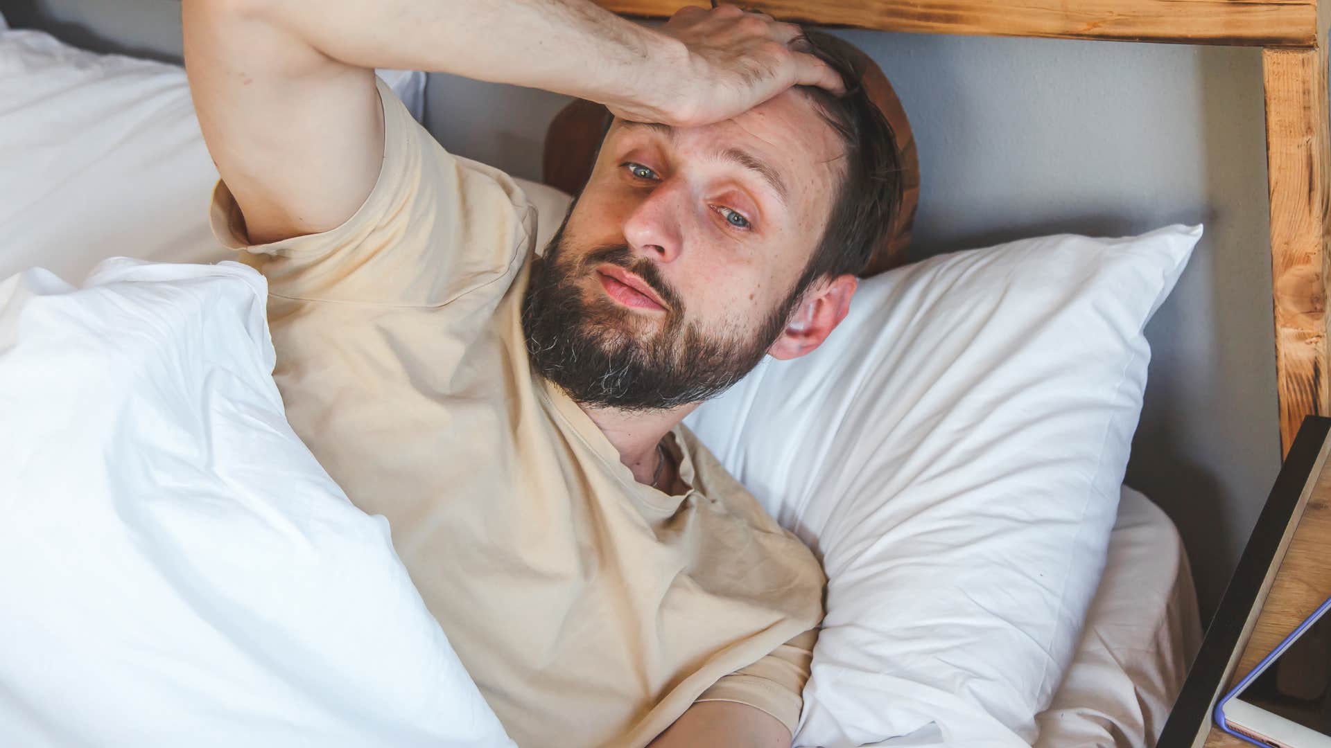 stressed man waking up from sleep feeling more tired