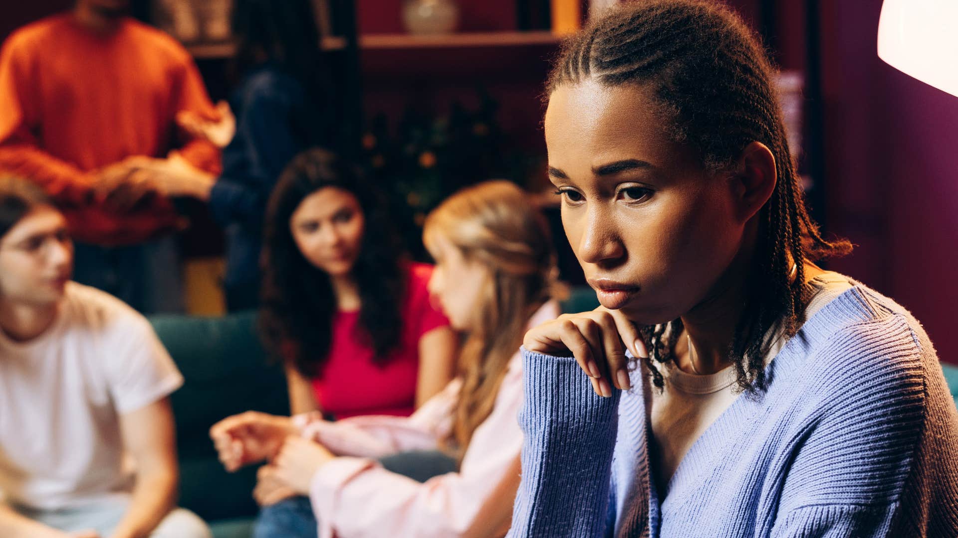 introverted woman sitting in a group of people feeling awkward