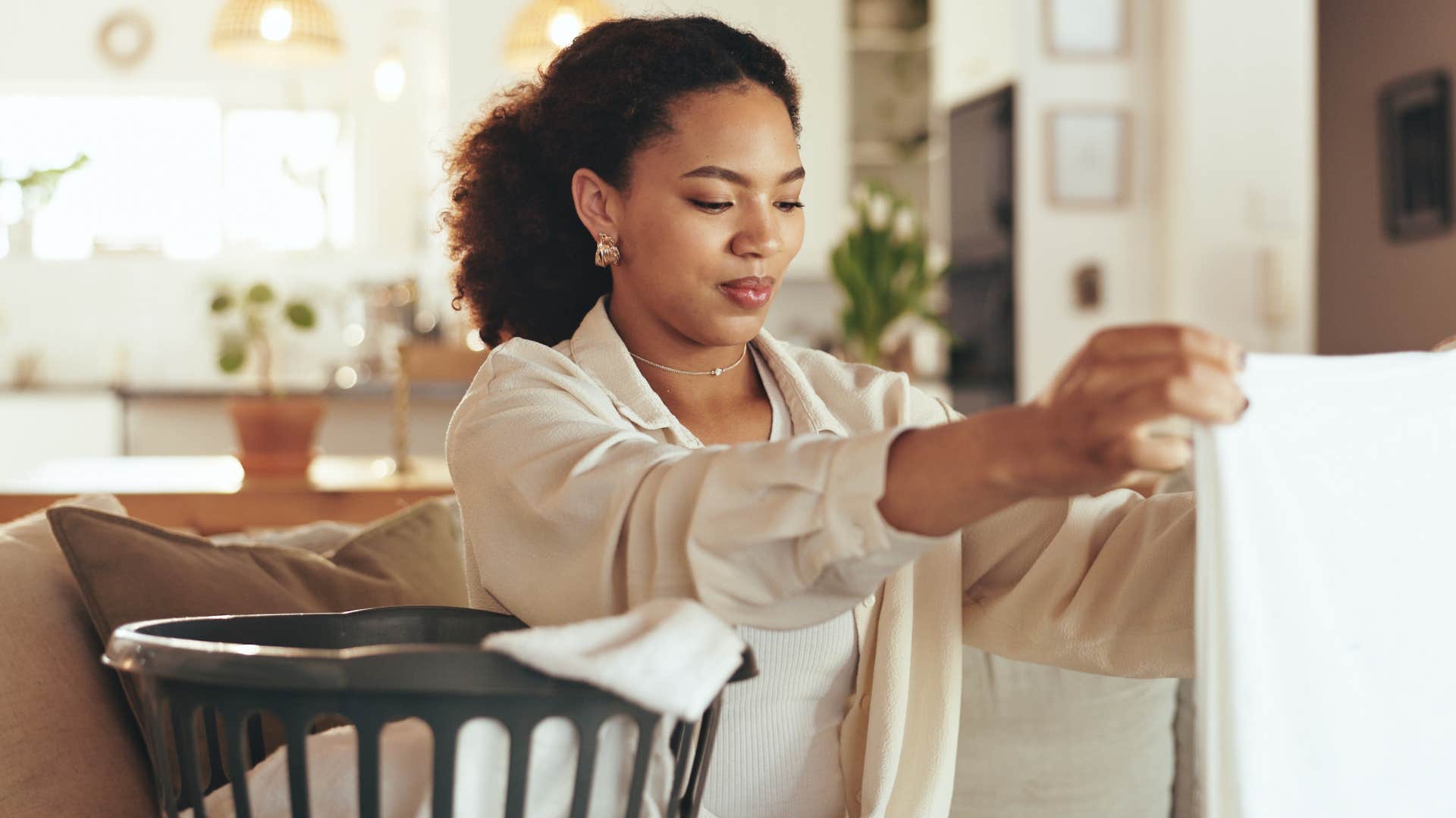 focused person fold laundry as part of routine after job loss