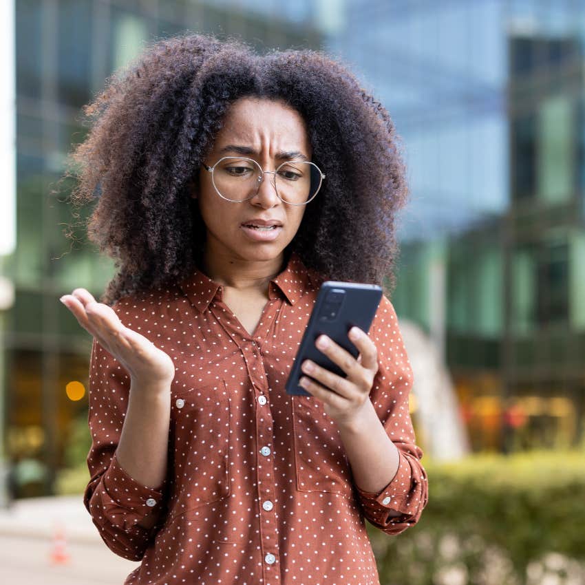 woman looking at her phone frustrated she cant fix a problem immediately