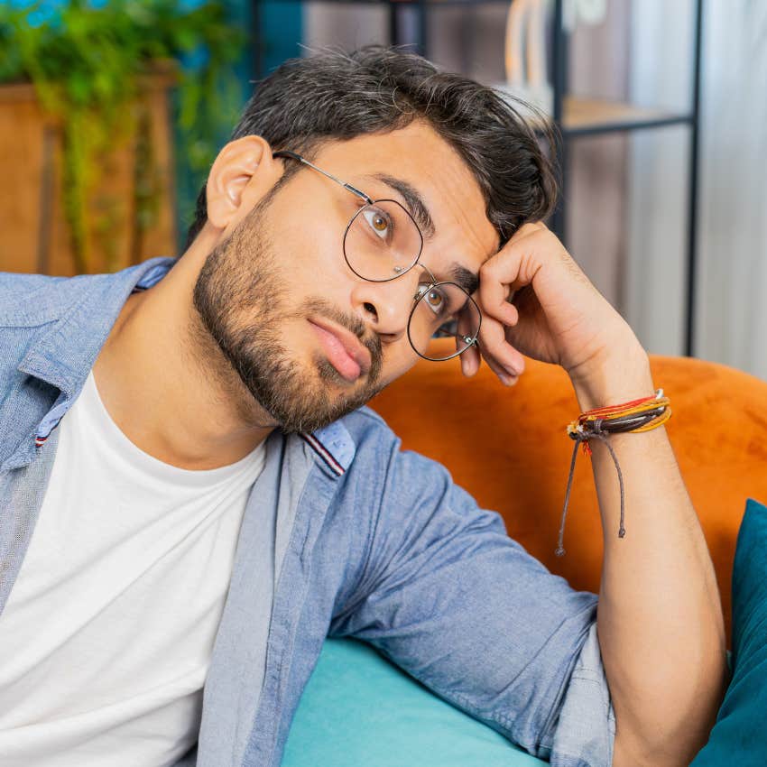 upset man sitting on couch feeling hyper-aware about textures around him