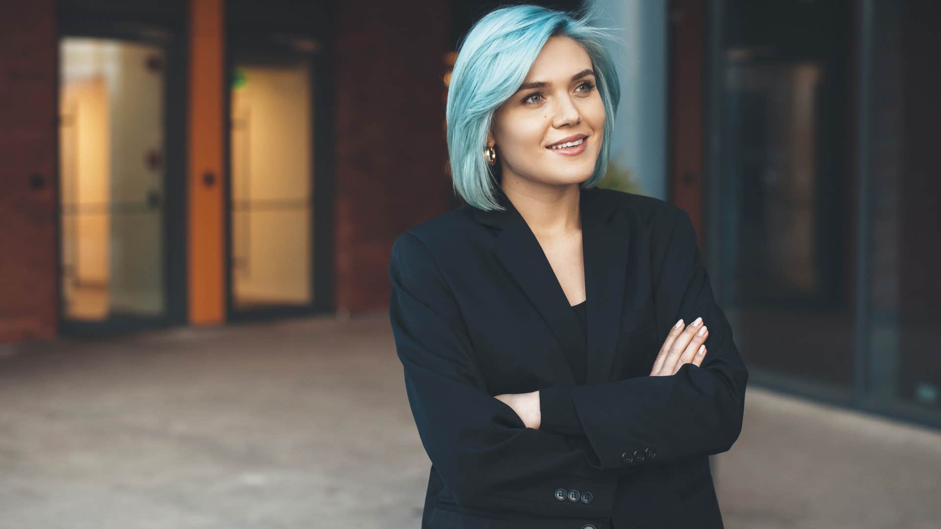 open-minded woman with blue hair standing outside