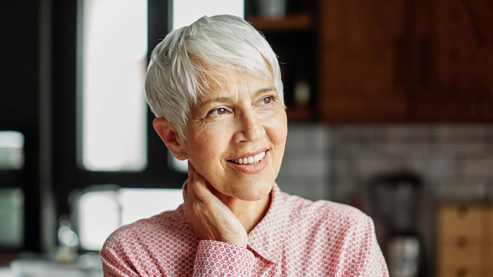 older emotionally cautious woman smiling after being upset