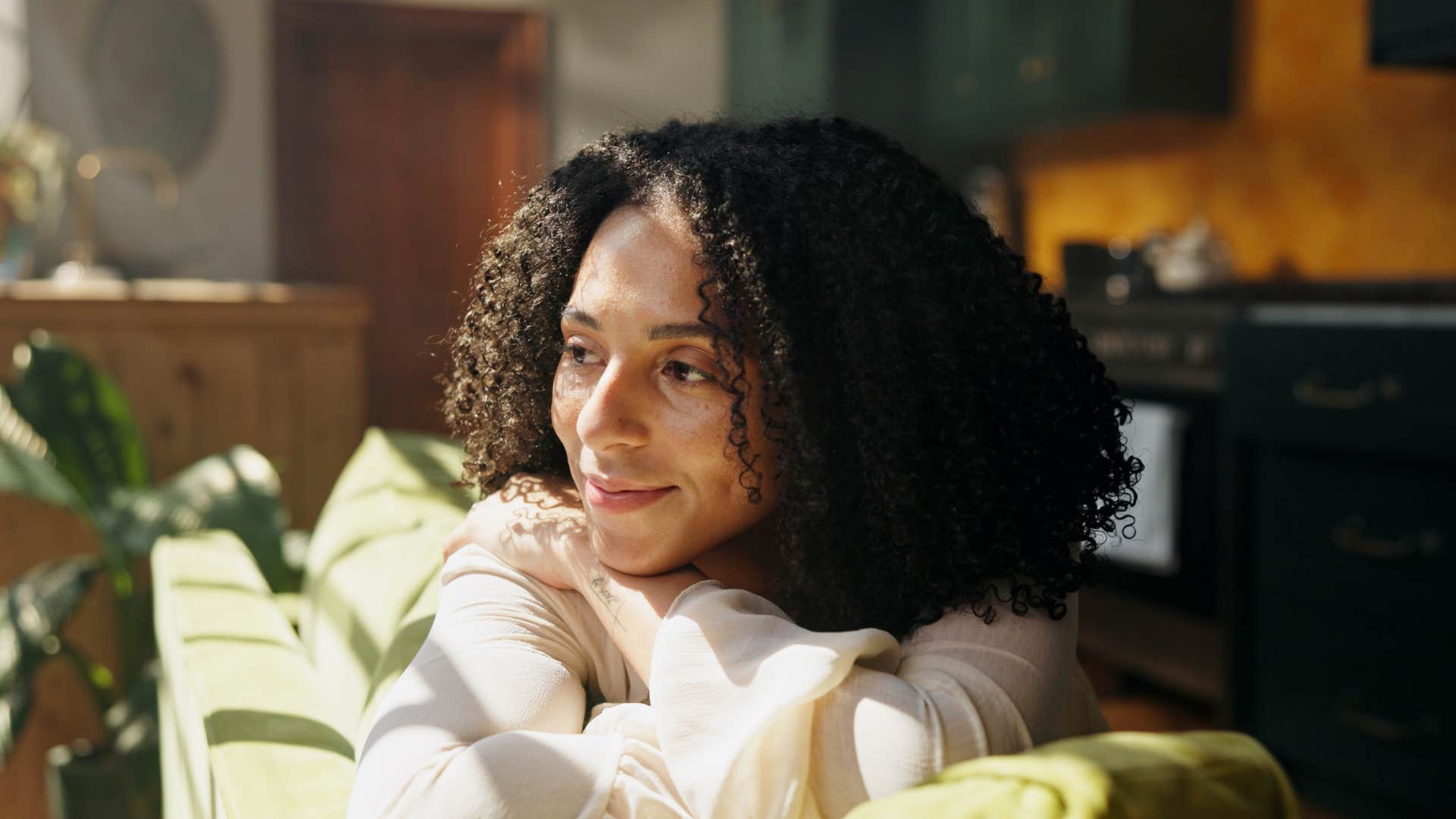 resilient woman looking out a window thinking
