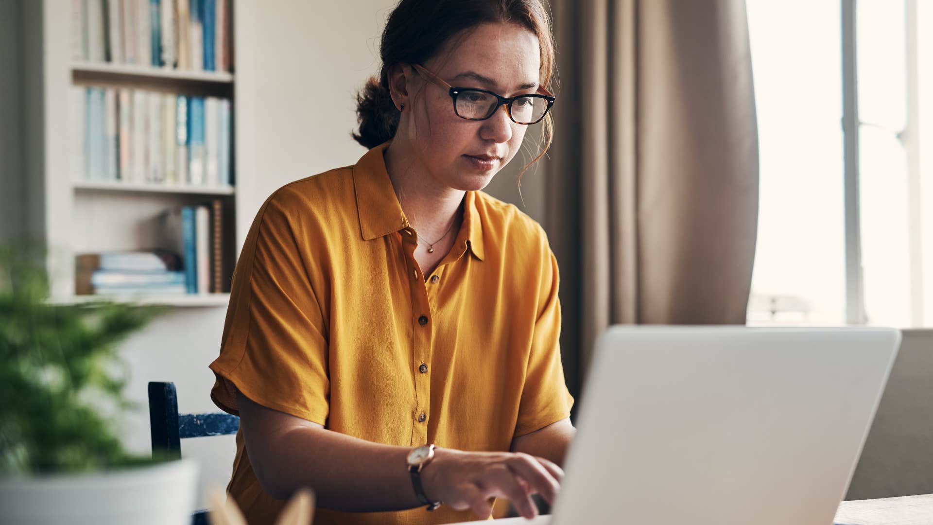 self-reliant woman working on laptop silently