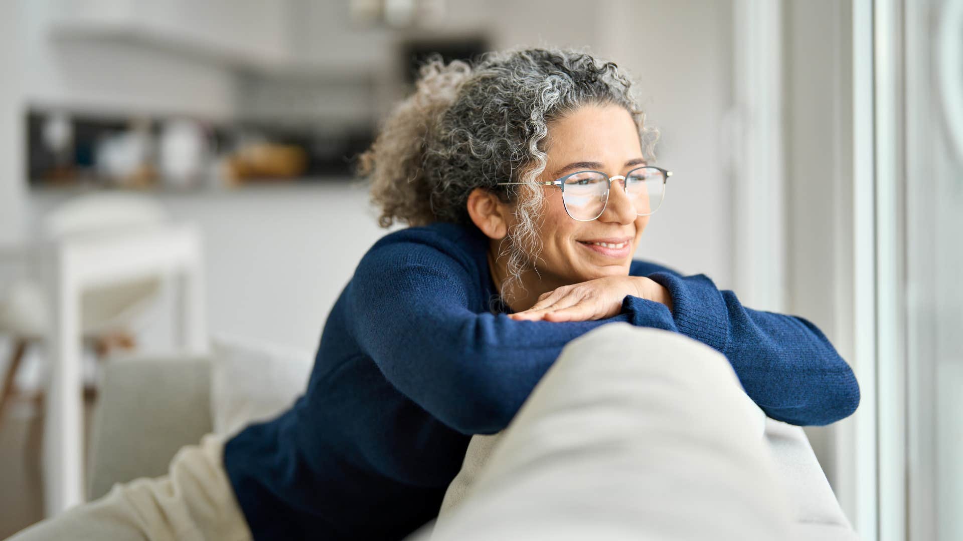 Happy older person looks out window showing big dreams