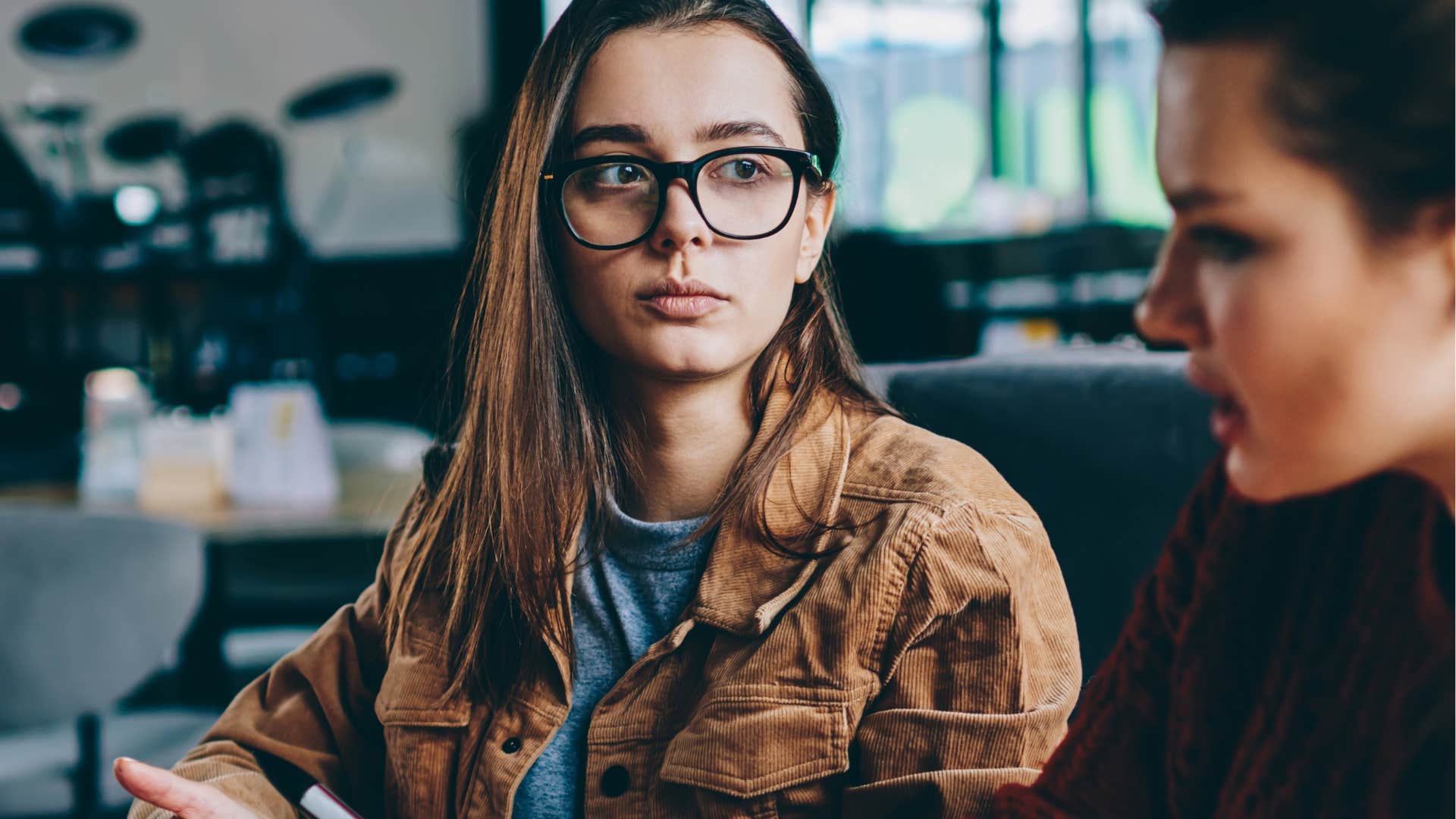 annoyed woman saying that's so embarrassing to a friend