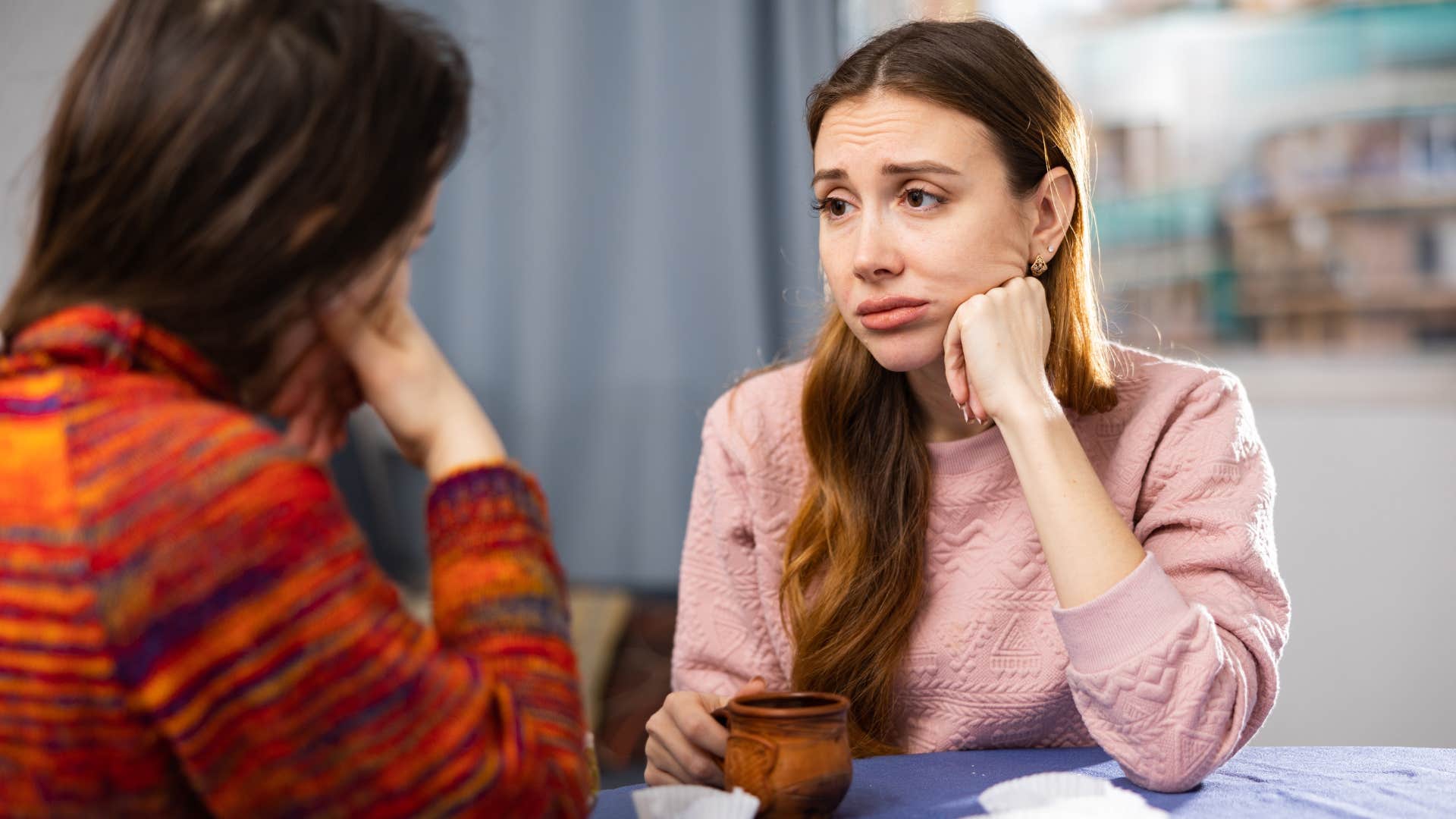 overly empathetic woman feeling sad listening to friend talk