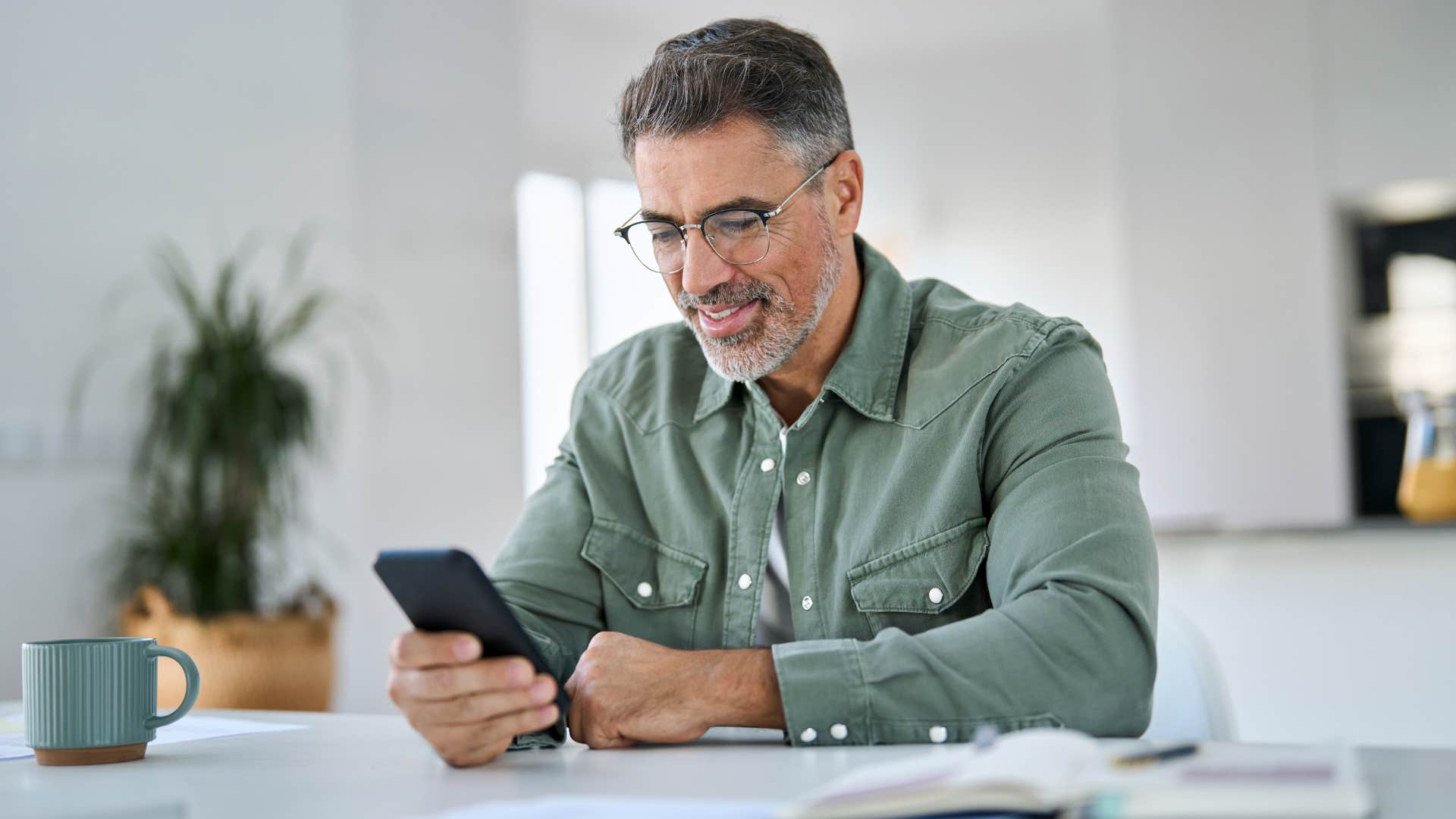 intentional man scrolling on his phone at home