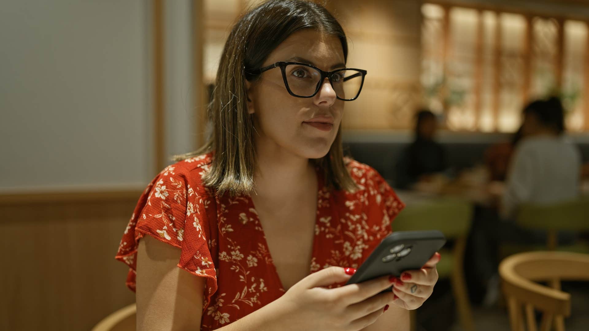 sensitive and easily overstimulated woman sitting in a busy restaurant