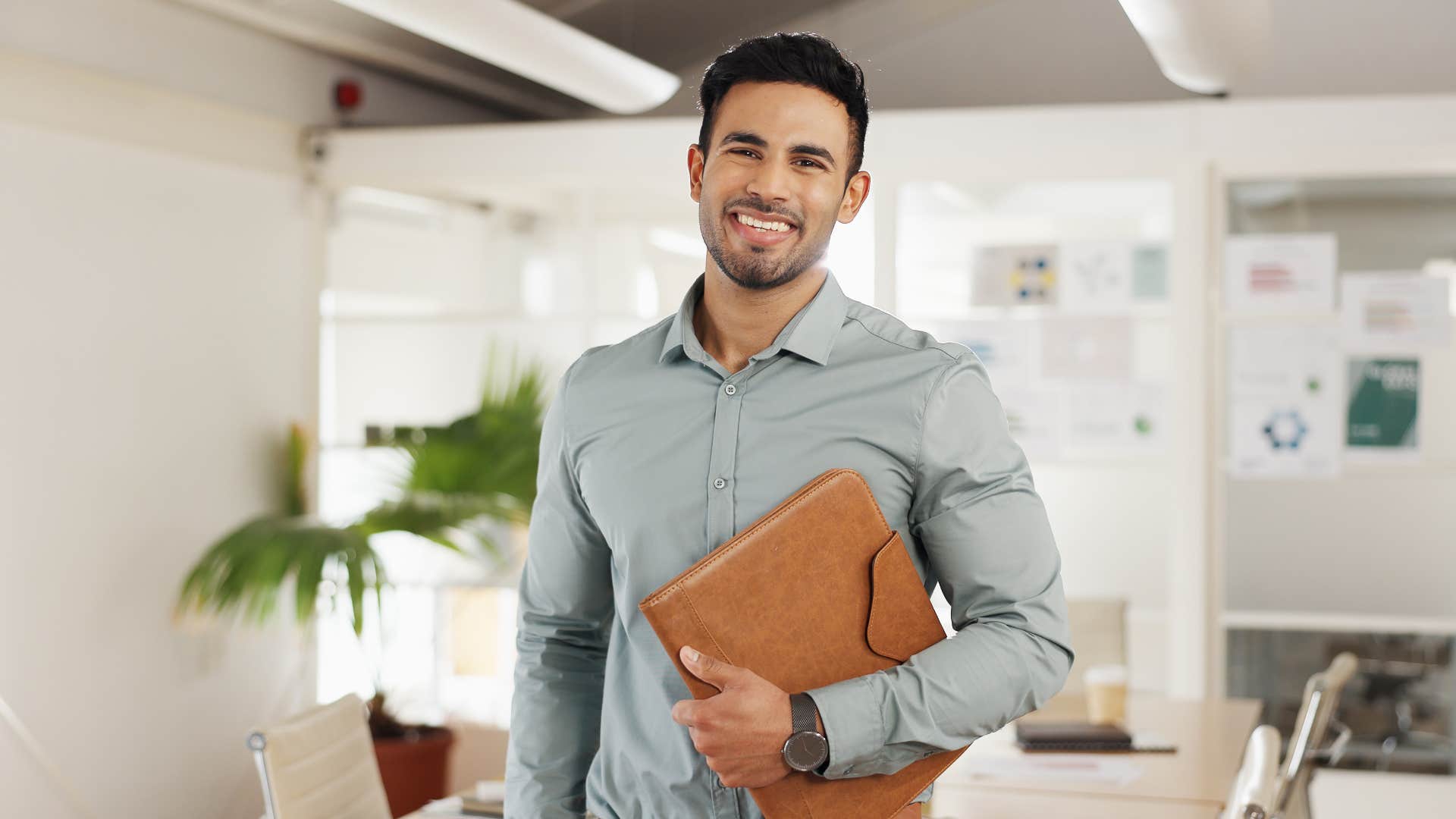 man holding folder while standing in office