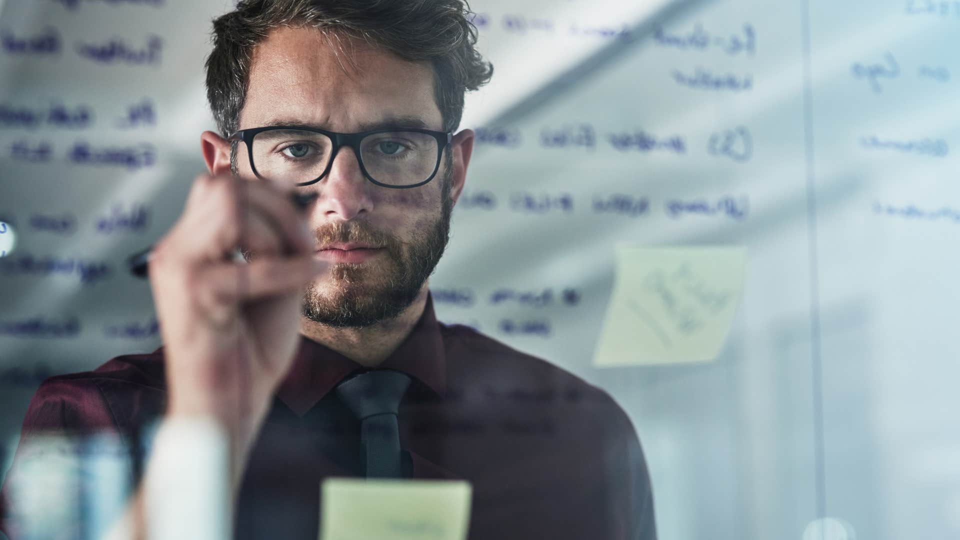 man writing on board