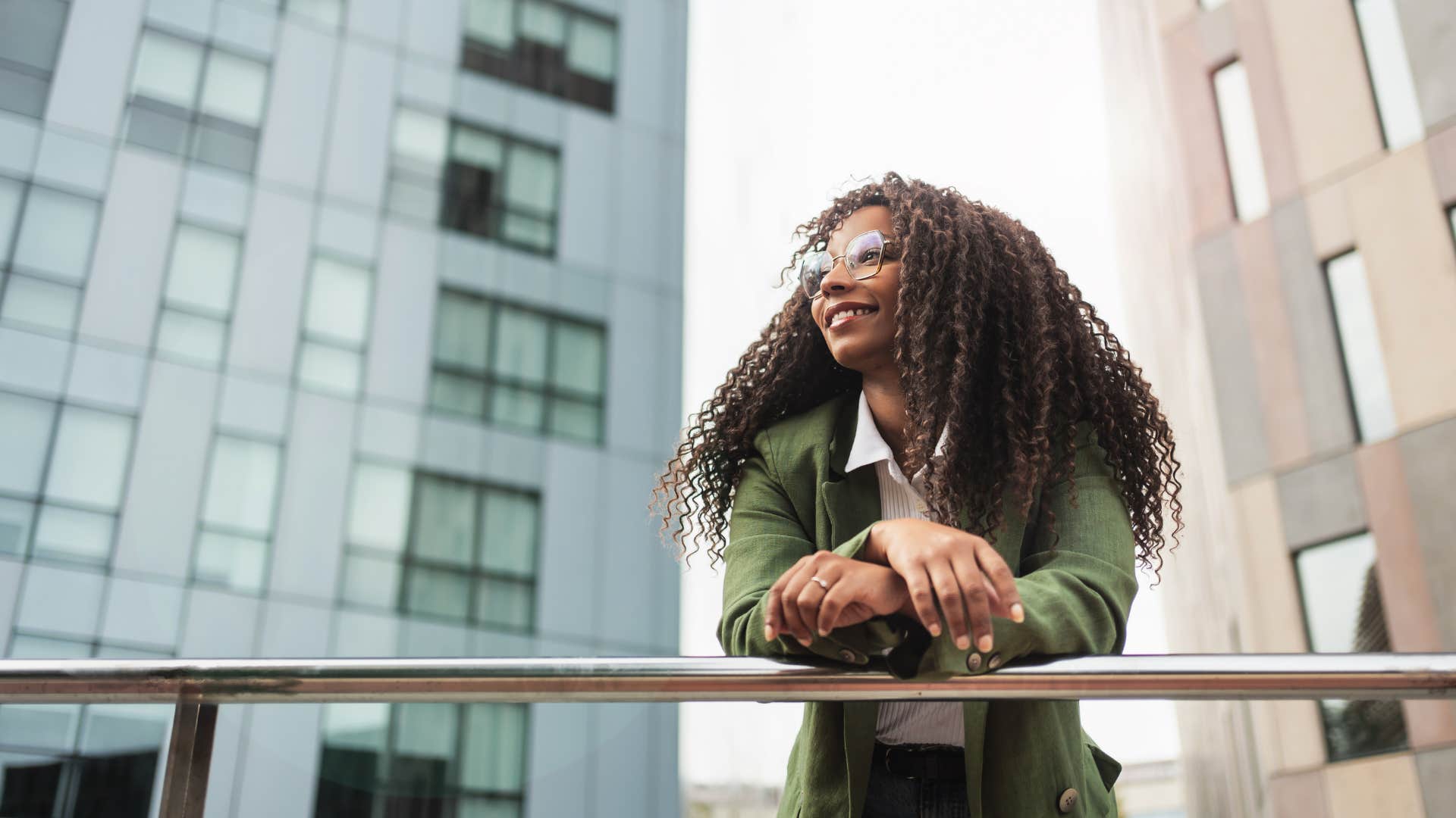 Confident business person leans on hand rail to get centered before interview