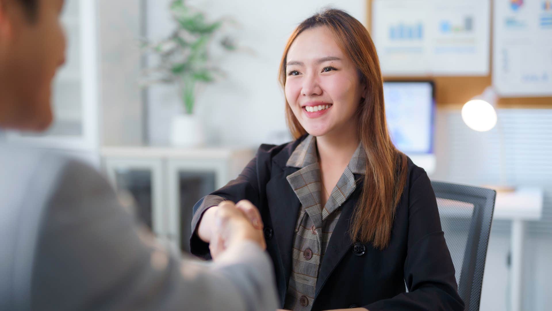 Successful people shake hands after interview showing importance of studying organization