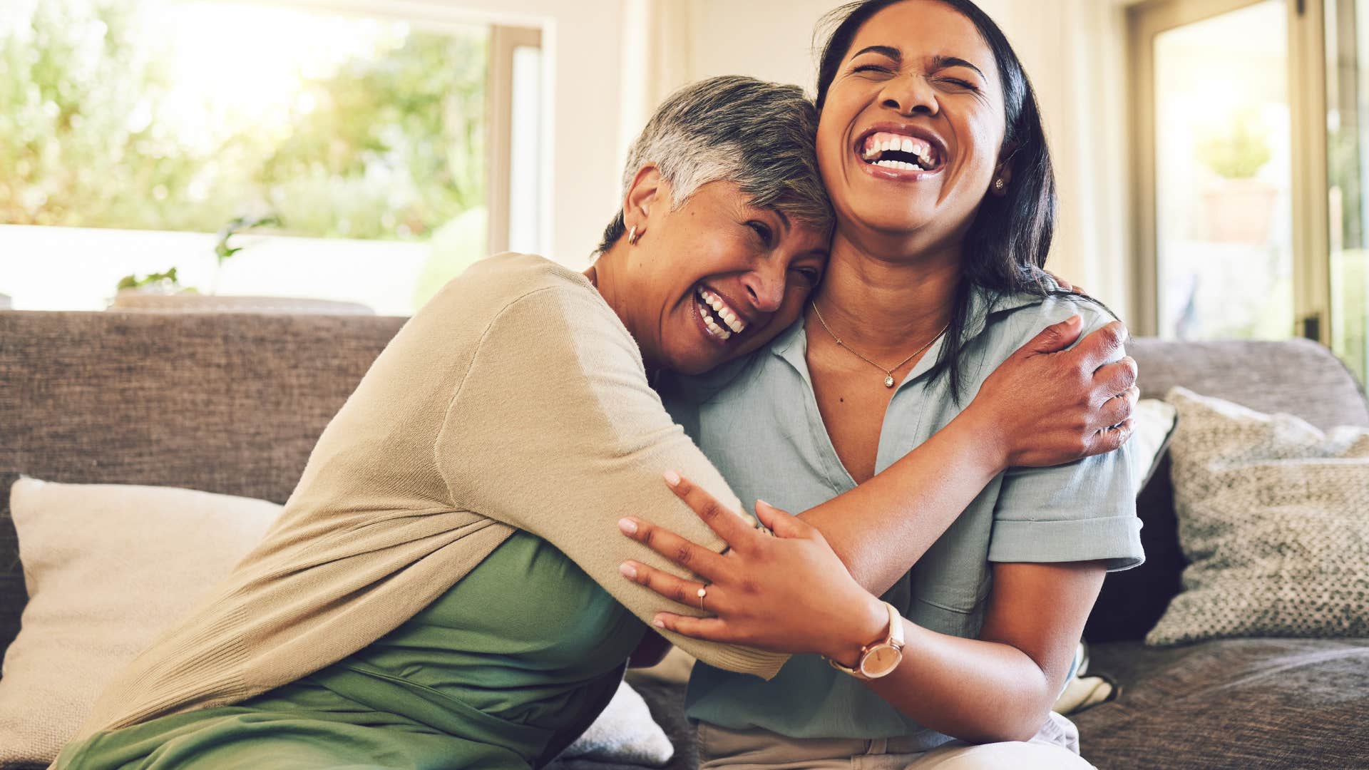spontaneous women hugging each other laughing