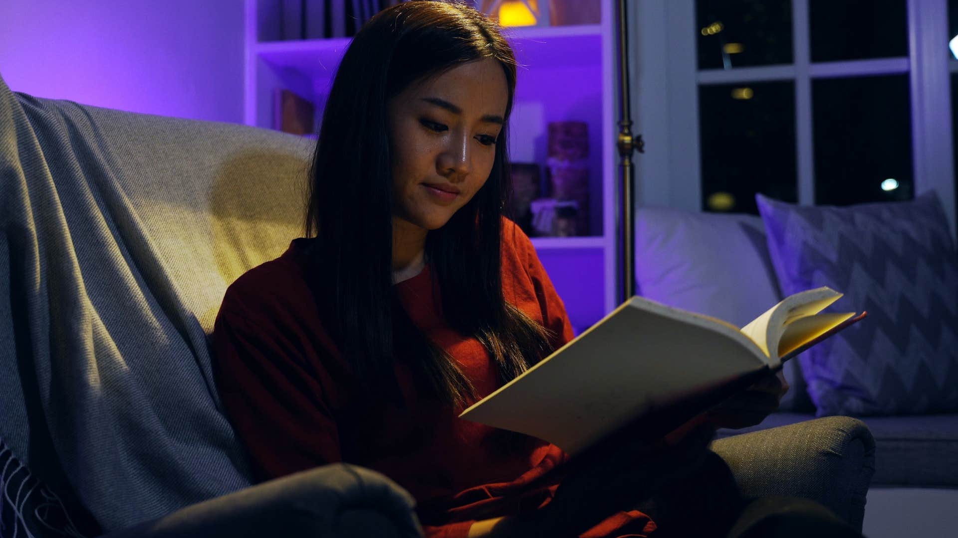 incredibly curious woman reading a book at night