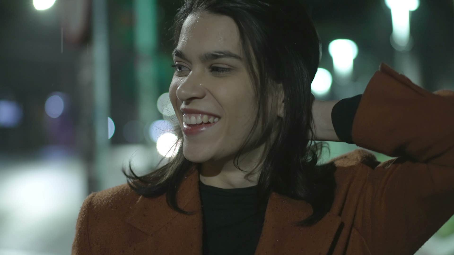 unconventional woman smiling outside at night