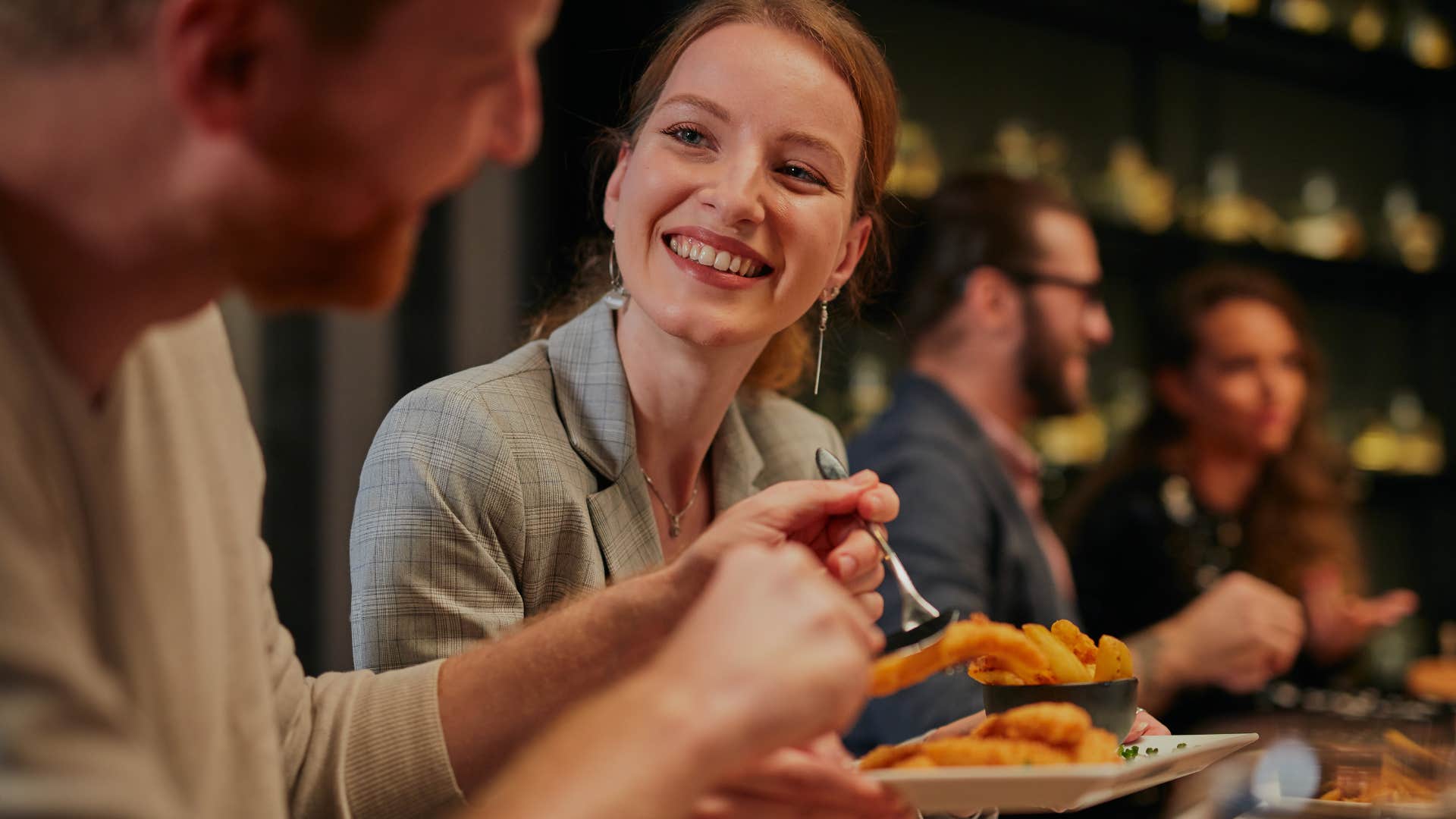 consistent and reliable woman smiling at a dinner table