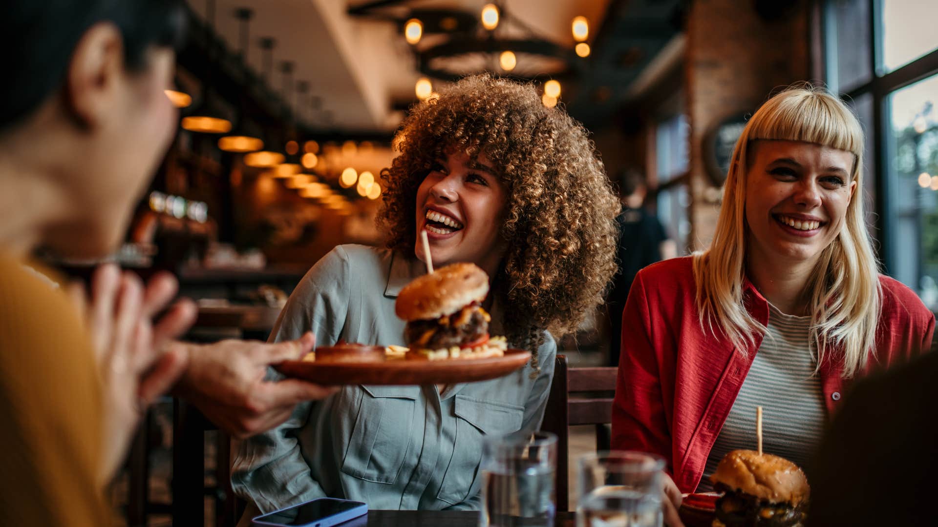 efficient woman smiling in a restaurant with friends