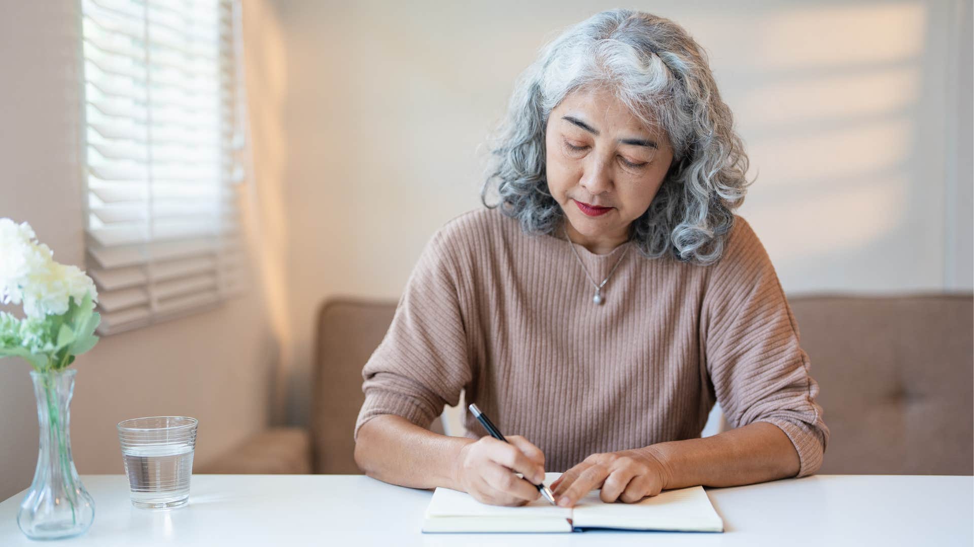 older person writes in journal to stay positive