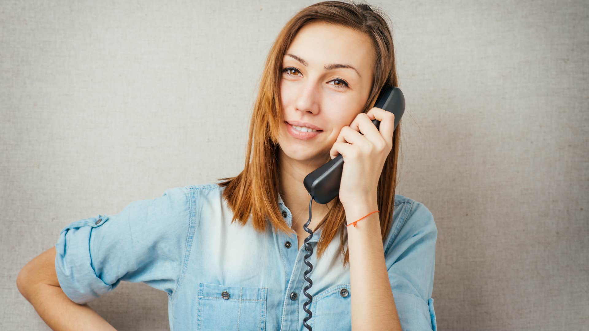 woman who appreciates phone etiquette talking on a landline