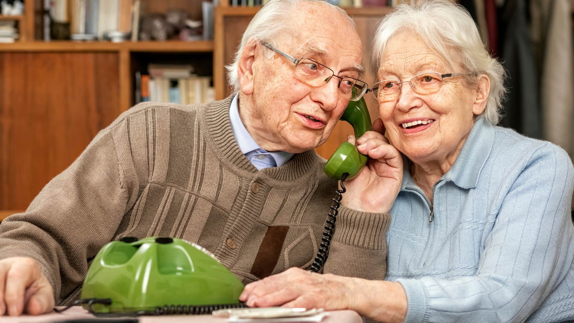 patient couple sharing a landline phone at home