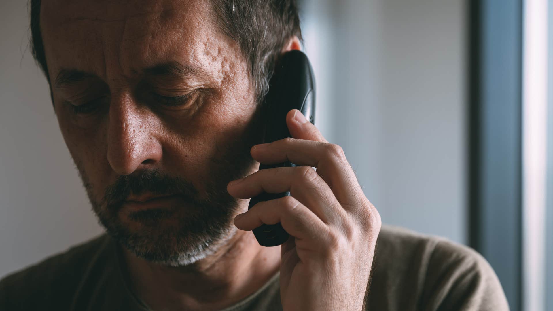 sentimental man talking on a landline phone