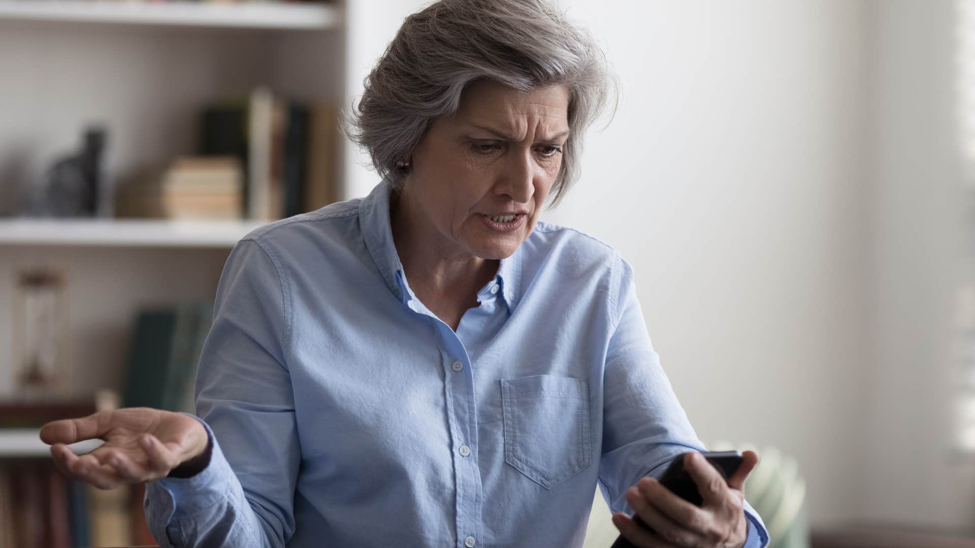 older woman who's skeptical of modern technology upset with her phone