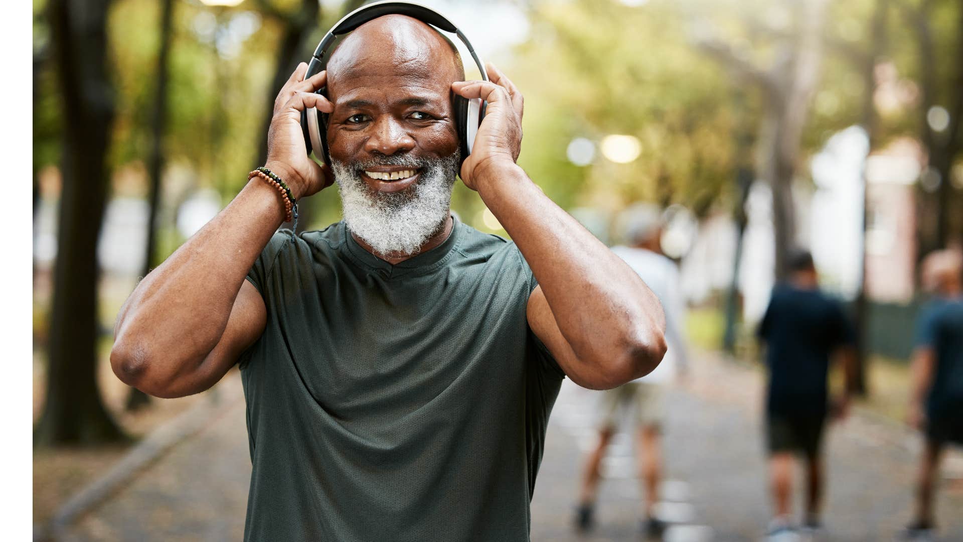 sentimental man listening to music in headphones outside