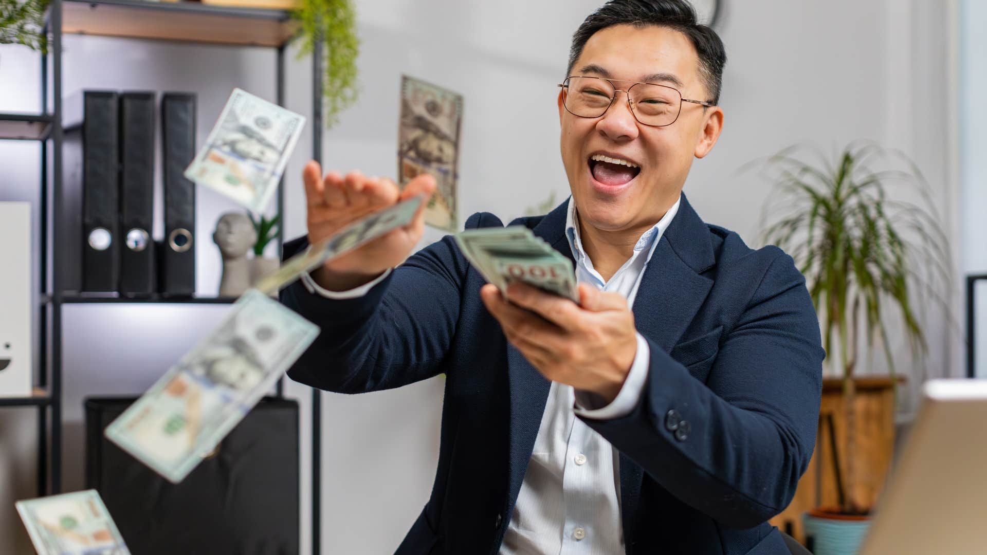man flaunting his wealth throwing cash at work
