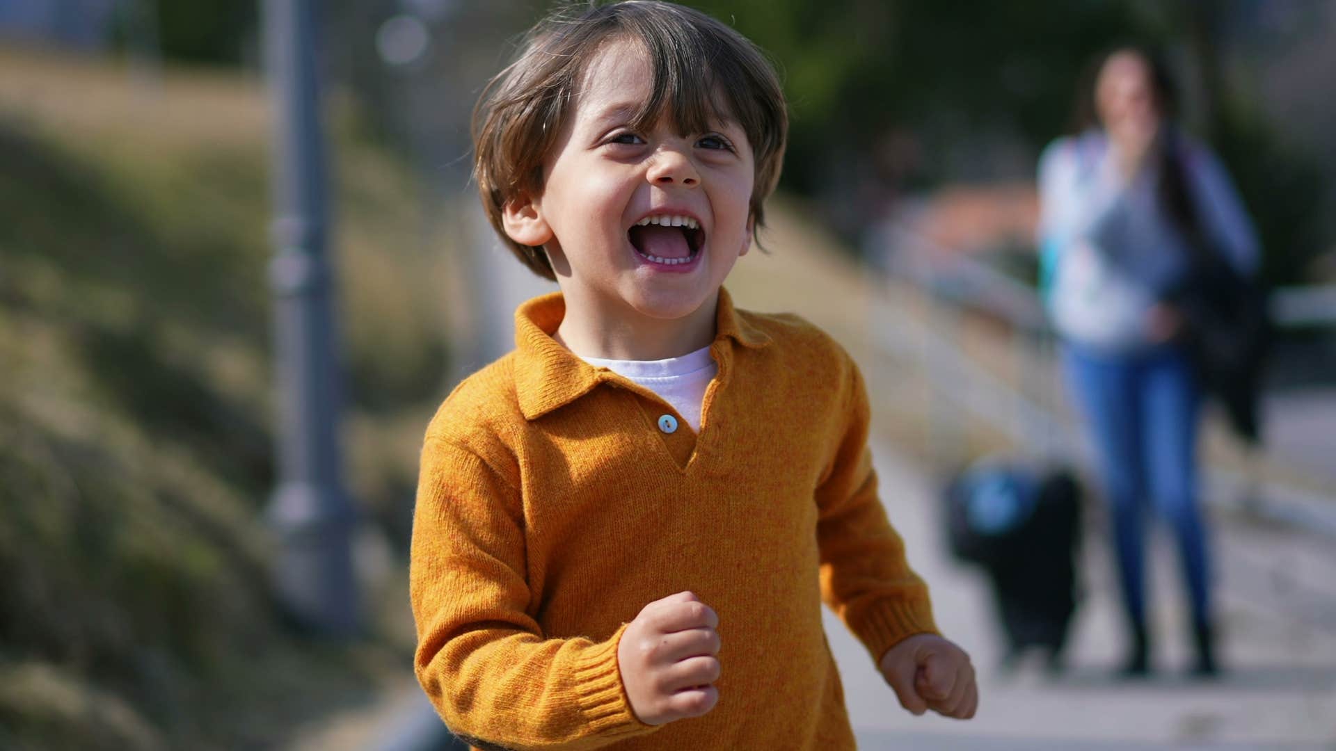 little boy running around entertaining himself without a screen