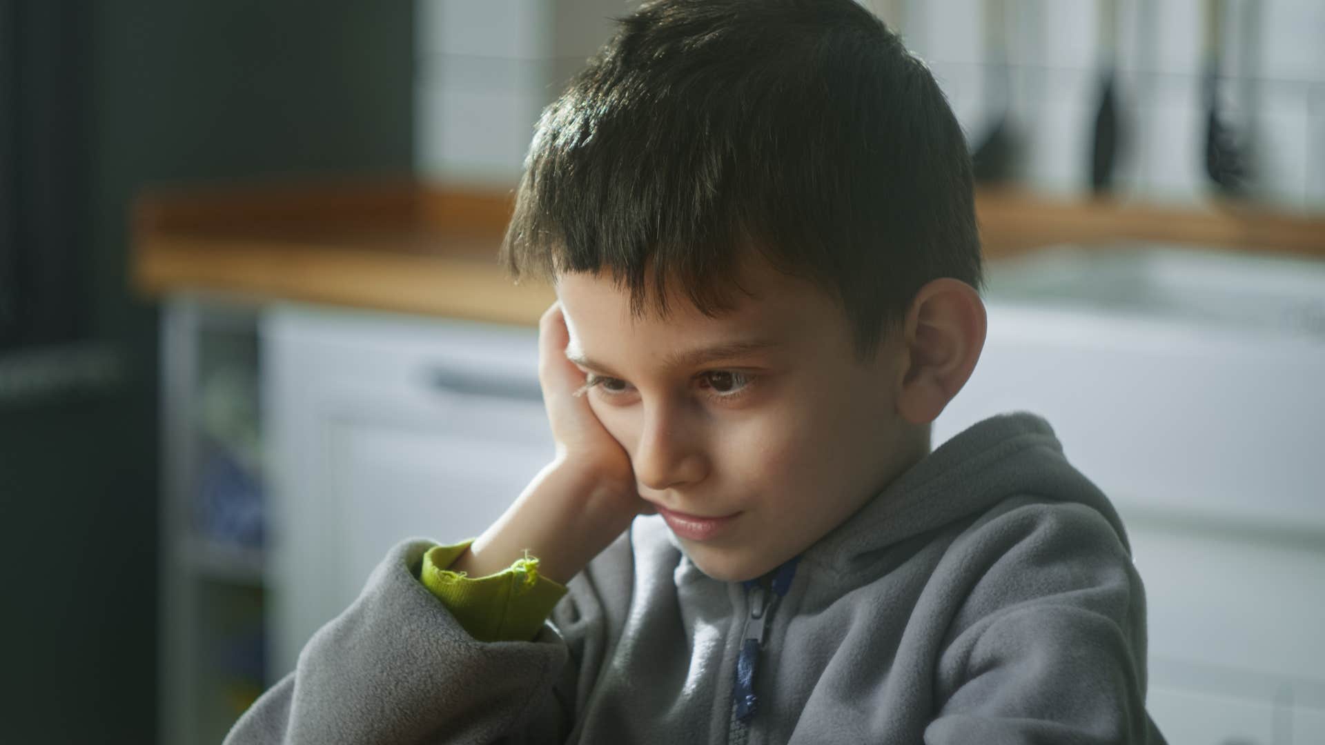 little boy spending time alone with his thoughts at home