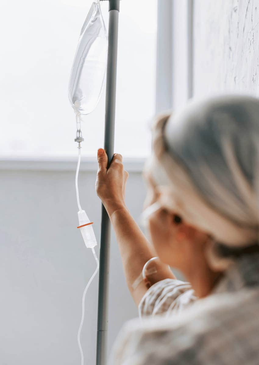 person holding on to iv pole