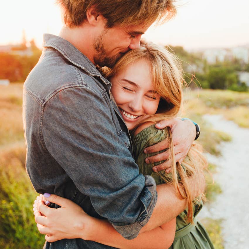 truly happy woman feels loved while being hugged by boyfriend