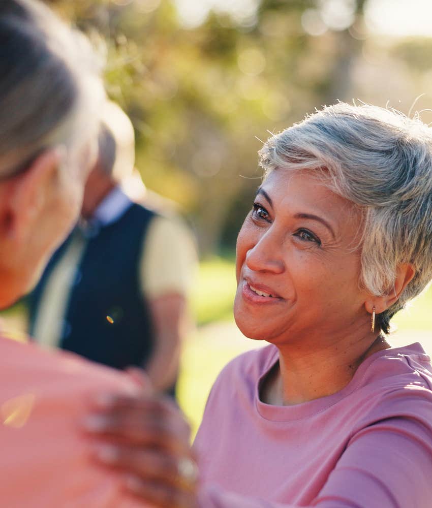 Smiling person softly touches friends shoulder